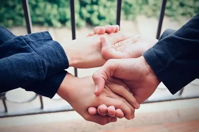 Two friends holding hands to show loyalty
