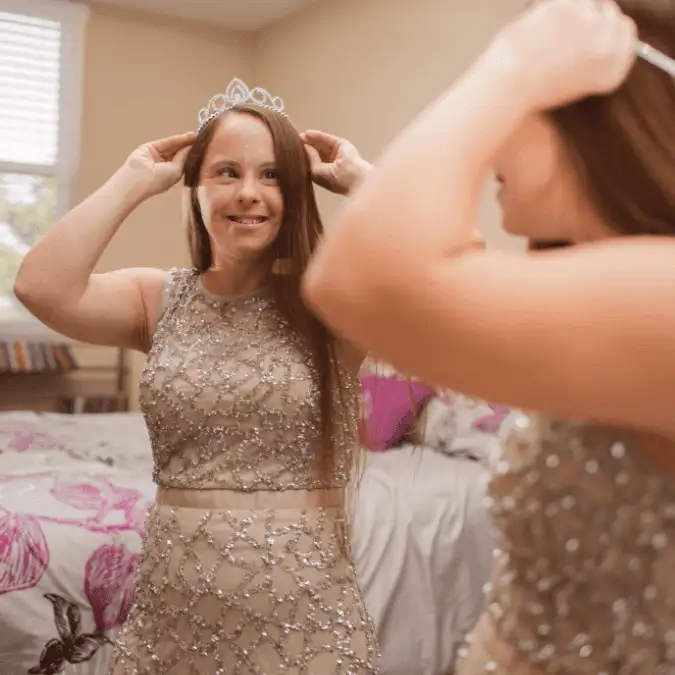 A woman putting on a crown