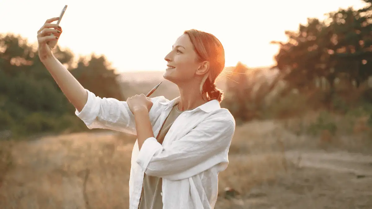 Happy woman taking selfie in nature