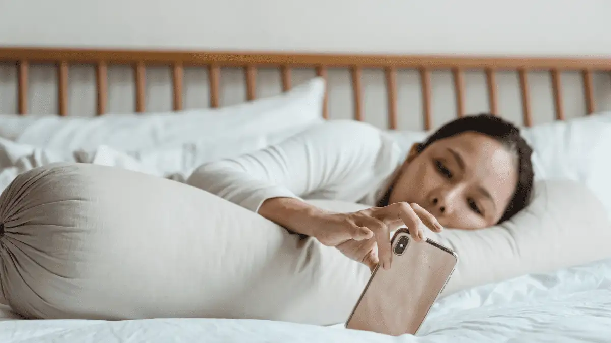 A woman distracted by her smart phone to show why people procrastinate