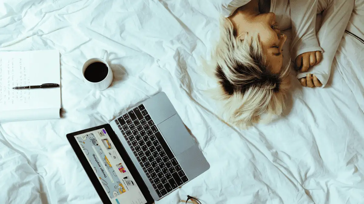 A lazy freelancer lying on the bed to demonstrate why people procrastinate so much