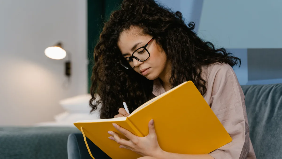 a woman writing down her new year habits