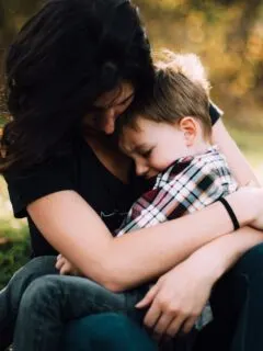 woman hugging boy on her lap