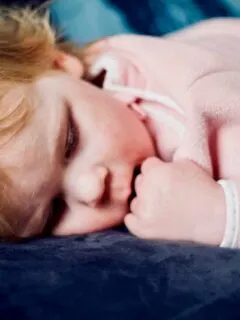 baby sleeping on black surface