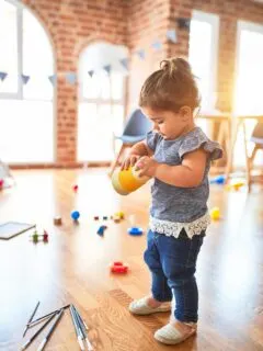 girl in blue denim dungaree pants holding blue and white polka dot handbag